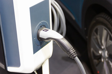 the charging the battery for the car new Automotive Innovations the power supply plugged into an electric car being charged, concept of energy innovation.