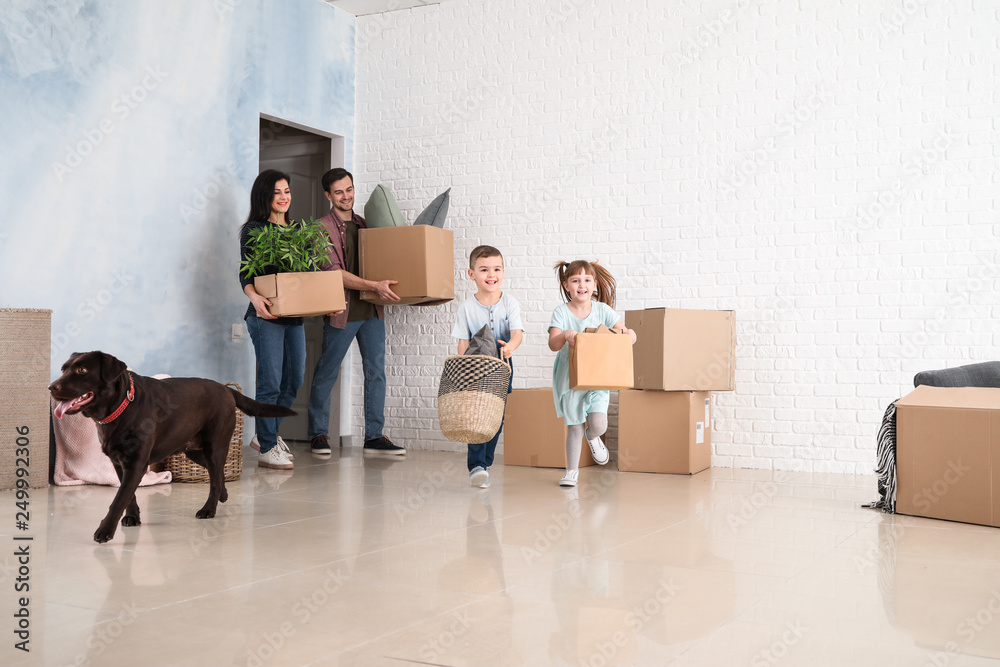 Wall mural family with cardboard boxes after moving into new house