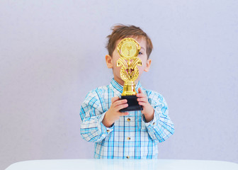 funny boy age three years old, holding in holding a trophy