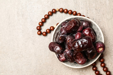 Bowl with tasty dates on table