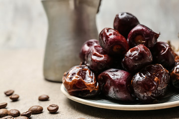 Plate with tasty dates on table, closeup
