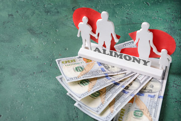 Composition with figure of family, money and paper with text ALIMONY on table
