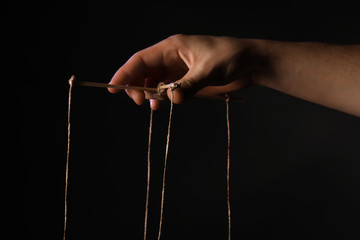 Hand of puppeteer on dark background