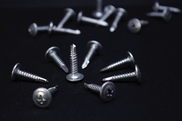 Screws and nuts on black background