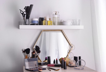 Professional makeup cosmetics on dressing table in room