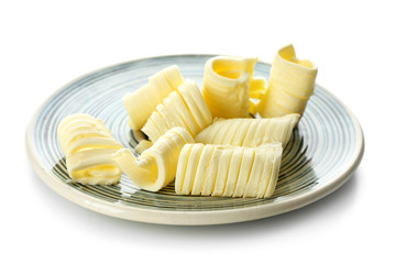 Plate with butter curls on white background