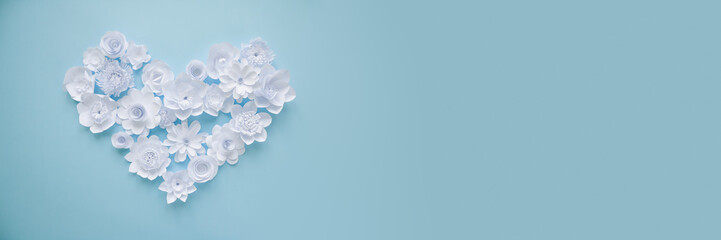 Heart from white paper flowers on blue background