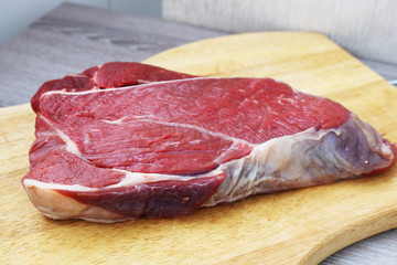 Fresh raw beef steak  on wooden background, top view 