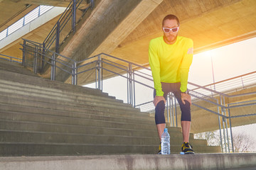 Fototapeta premium Sportsman working out / jogging on a big city urban bridge.