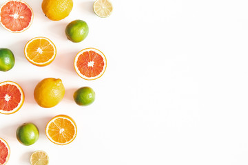 Fruits and palm leaves on white background. Citrus fruits. Summer concept. Flat lay, top view, copy space