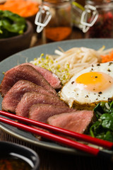 Korean beef with sprouts, spinach and fried egg.
