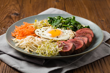 Korean beef with sprouts, spinach and fried egg.