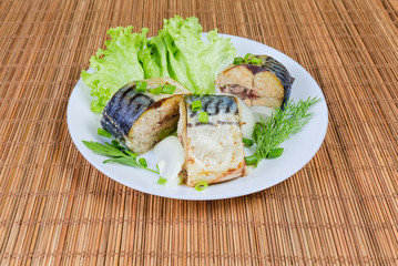 Baked slices of Atlantic mackerel with greens on dish