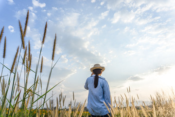 Girl wearing a hat Sitting looking at desho grass.