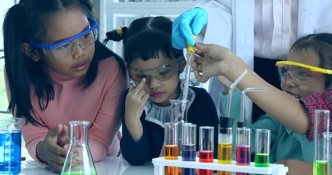 Close up scene video of science teacher teach Asian students in laboratory room,  Student drop something into beaker, concept for study in laboratory room.