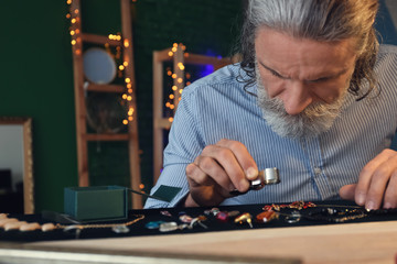 Jeweller examining adornment in workshop