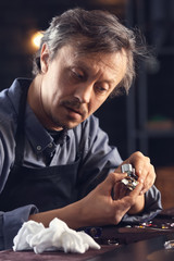 Jeweller examining adornment in workshop