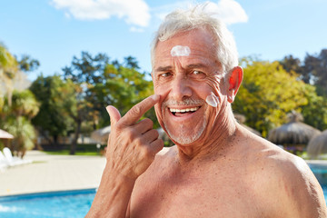 Senior cremt Gesicht mit Sonnencreme ein