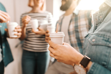 Close up of hands holding coffee to go. Start up business concept.