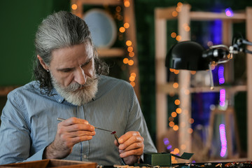 Jeweller examining gemstone in workshop