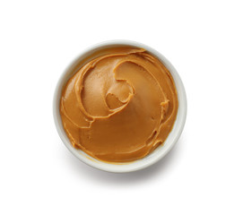 Tasty peanut butter in bowl on white background