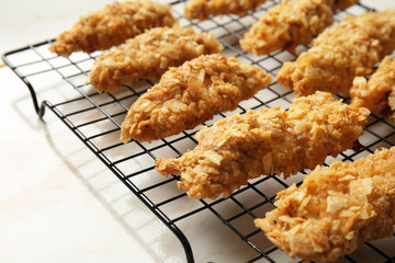 Cooling rack with tasty nuggets on light table, closeup