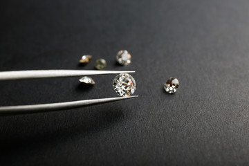 Pincer with precious stone for jewellery on dark background