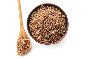 Bowl with tasty boiled buckwheat on white background