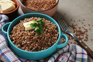 Pot with tasty boiled buckwheat on grey table