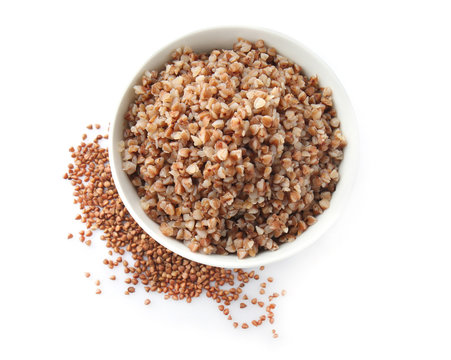 Bowl with tasty boiled buckwheat on white background