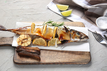 Grilled mackerel fish with lemon on wooden board