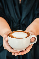 Female hands holding cup of hot Coffee Cappuccino