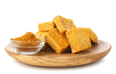 Wooden plate with tasty tofu cheese and spices on white background