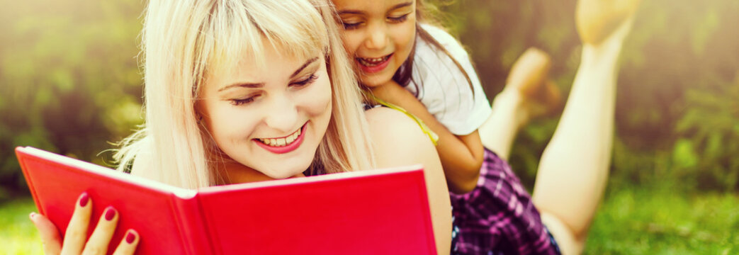 Happy Latino Family Reading Book At Park