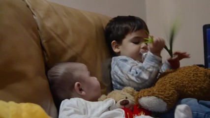 Brothers sitting on the couch - 3 months old baby boy and his older brother two years old