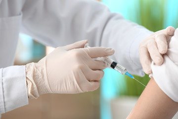 Doctor vaccinating woman against flu in clinic