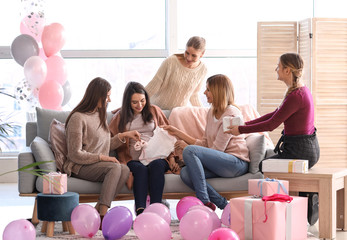 Pregnant woman with her friends at baby shower party - obrazy, fototapety, plakaty