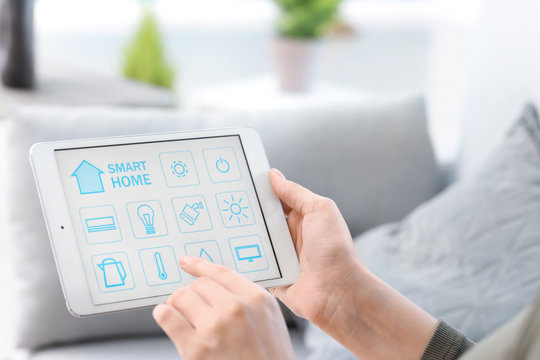 Young woman using application of smart home automation