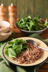 Bowl with tasty boiled buckwheat on table
