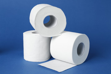 Rolls of toilet paper on color background