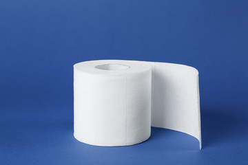Roll of toilet paper on color background
