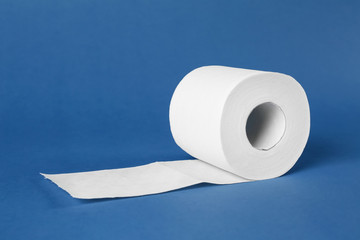 Roll of toilet paper on color background