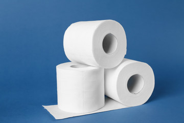 Rolls of toilet paper on color background