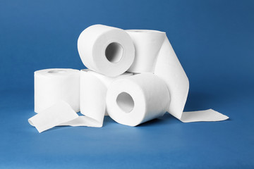 Rolls of toilet paper on color background