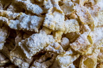 Close-up.Sweet dessert Angel wings.Deep-fried dough strips sprinkled with powdered sugar. Background for a site about regional cuisine, baking,sweets.