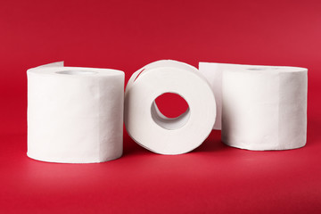 Rolls of toilet paper on color background