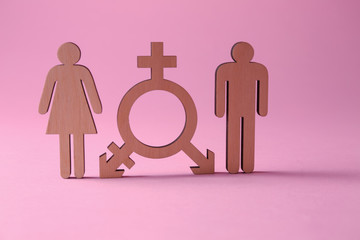 Female and male figures with symbol of transgender on color background