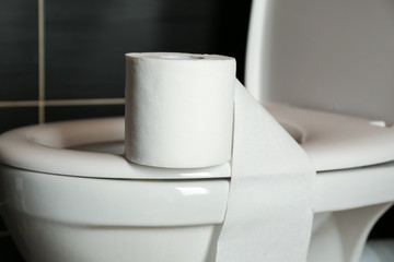 Roll of paper on toilet bowl in restroom