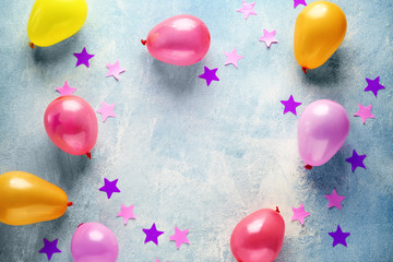 Frame made of birthday balloons with confetti on light background