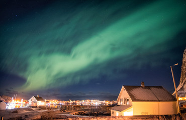 Aurora borealis dancing over scandinavian village